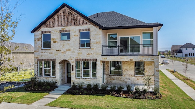 view of front of house featuring a balcony and a front yard