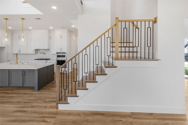 stairs with wood-type flooring and sink