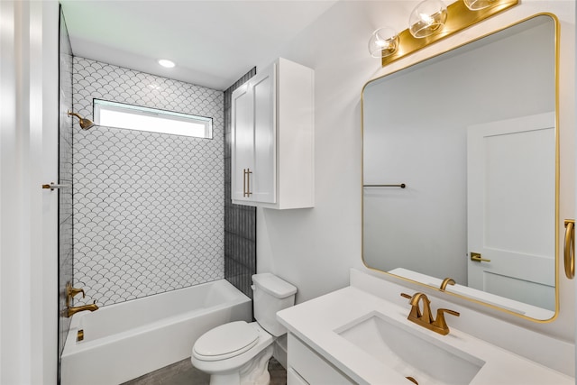 full bathroom featuring tiled shower / bath, vanity, and toilet