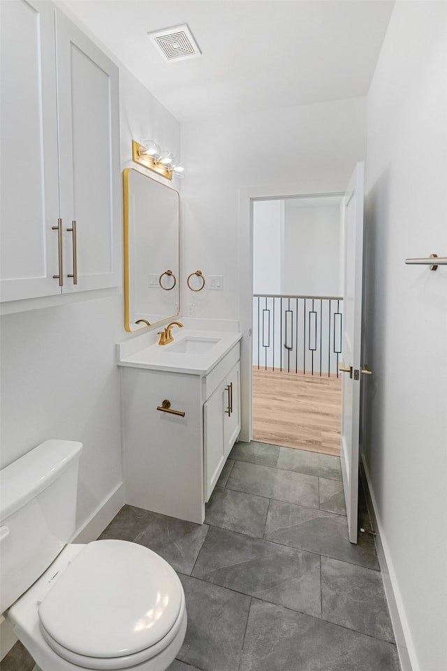 bathroom featuring toilet, hardwood / wood-style floors, and vanity