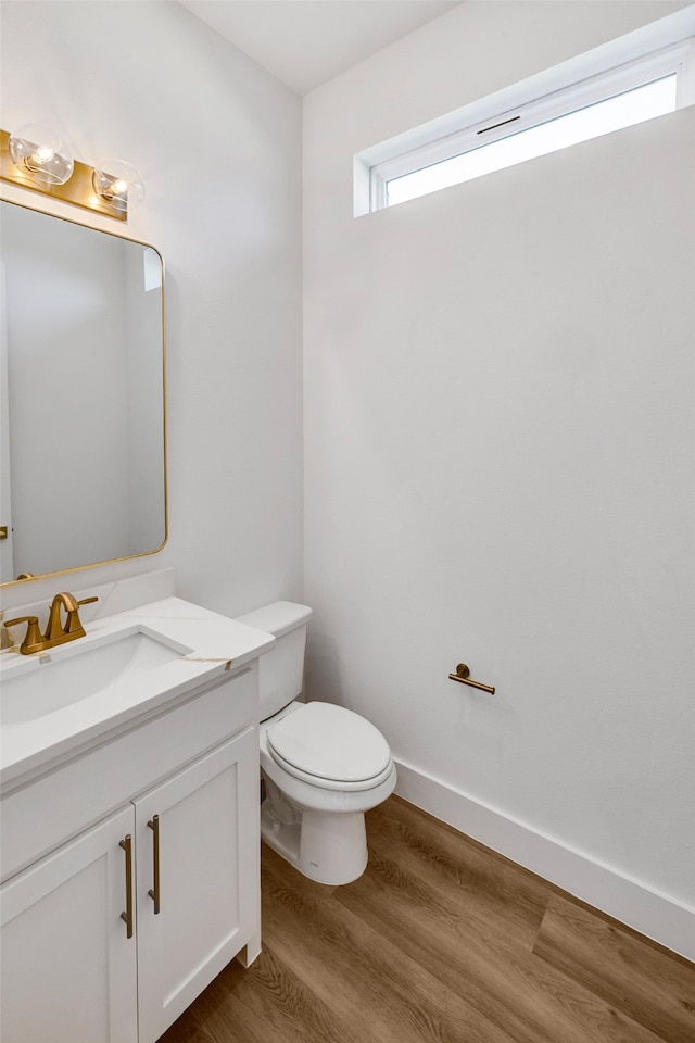 bathroom featuring vanity, toilet, and hardwood / wood-style floors