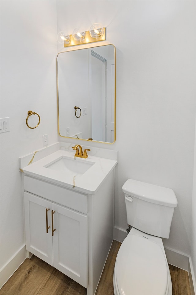 bathroom with vanity, toilet, and hardwood / wood-style flooring