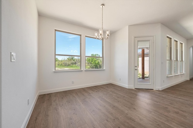 spare room featuring a chandelier and dark hardwood / wood-style flooring