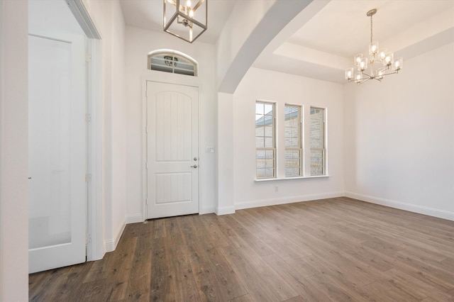 entrance foyer featuring dark hardwood / wood-style flooring and an inviting chandelier