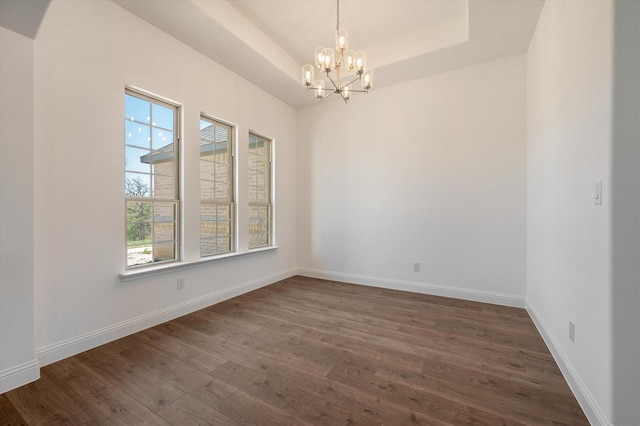 unfurnished room featuring a chandelier, dark hardwood / wood-style floors, and a healthy amount of sunlight