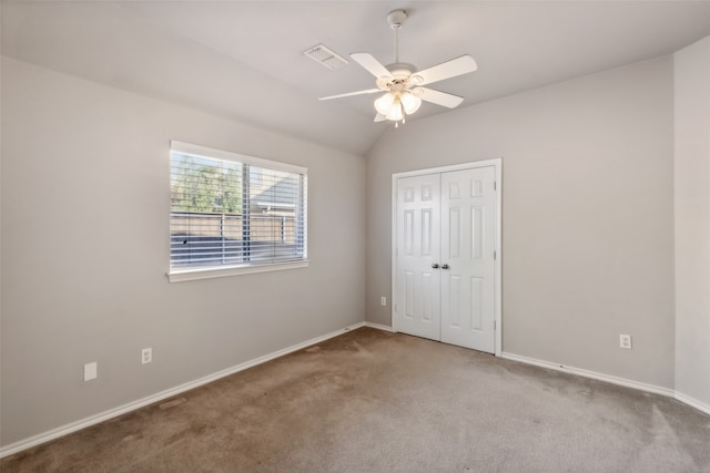 unfurnished bedroom featuring a closet, carpet flooring, vaulted ceiling, and ceiling fan