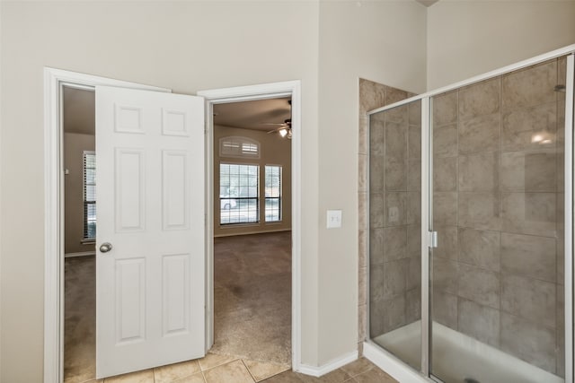 bathroom featuring a shower with door, ceiling fan, and tile patterned flooring