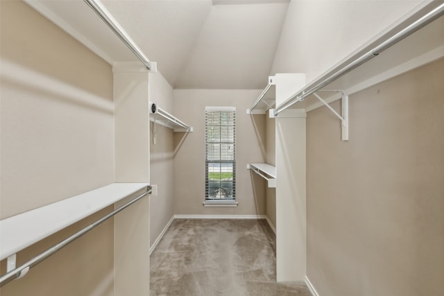 walk in closet featuring light carpet and vaulted ceiling