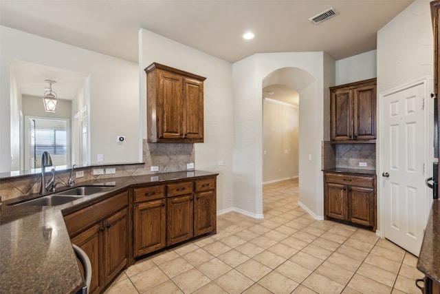 kitchen with backsplash, sink, and light tile patterned floors