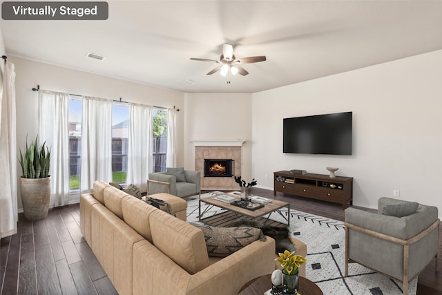 living room with dark wood-type flooring, a fireplace, and ceiling fan