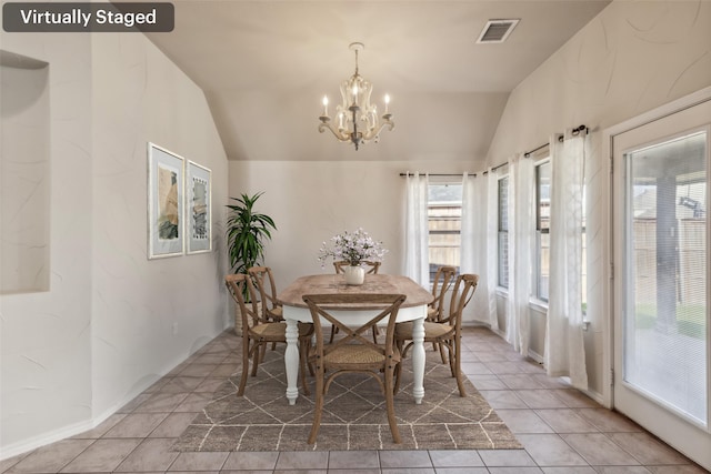 tiled dining area with an inviting chandelier, vaulted ceiling, and a healthy amount of sunlight