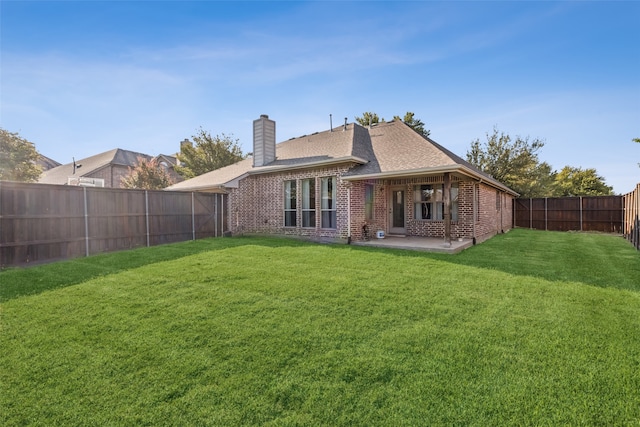 rear view of house with a patio and a lawn