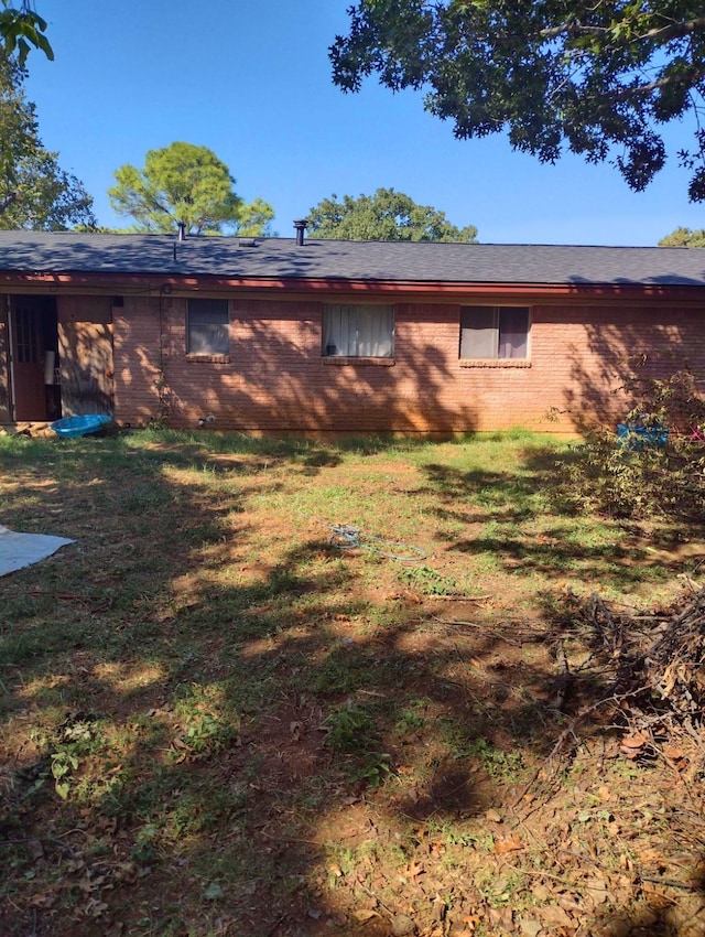 rear view of property featuring a lawn