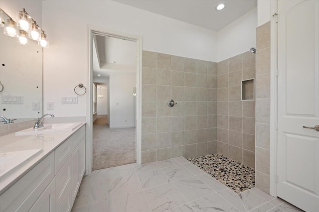 bathroom featuring a tile shower and vanity