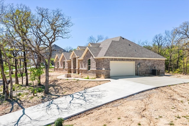 view of front of property with central AC and a garage