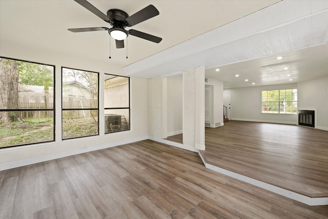 unfurnished living room with wood-type flooring and ceiling fan