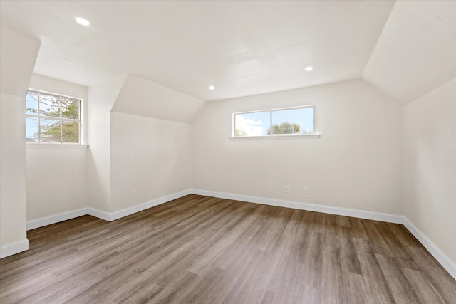 bonus room featuring a wealth of natural light, lofted ceiling, and light wood-type flooring