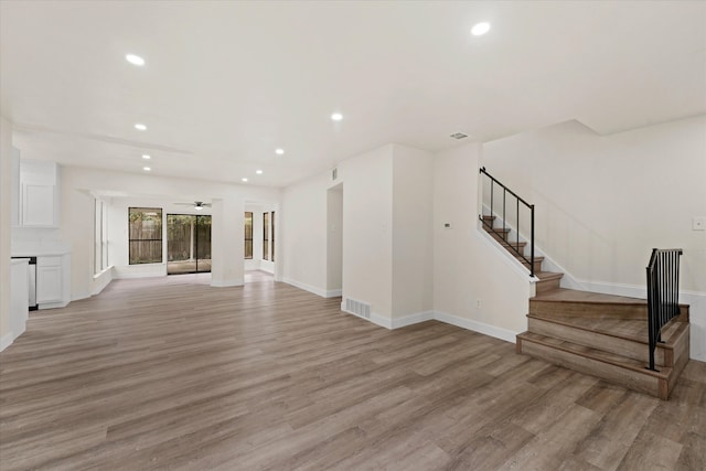 unfurnished living room with ceiling fan and light wood-type flooring