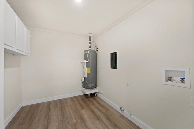 washroom featuring water heater, light hardwood / wood-style flooring, hookup for a washing machine, ornamental molding, and cabinets