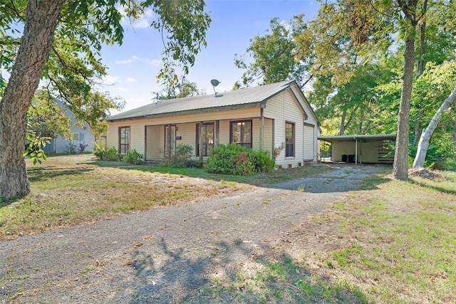 view of front of property featuring a carport, a porch, and a front lawn