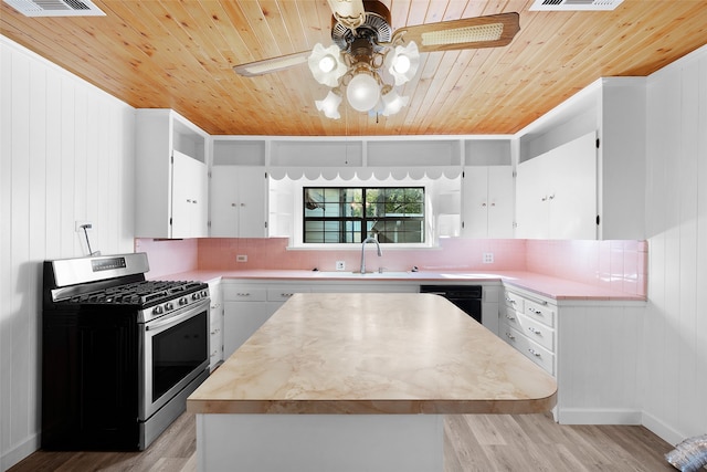 kitchen with backsplash, white cabinets, light hardwood / wood-style floors, and stainless steel range with gas stovetop