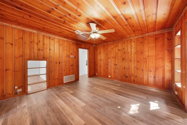 unfurnished room featuring wooden walls, light hardwood / wood-style flooring, ceiling fan, ornamental molding, and wood ceiling