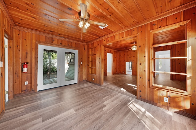 unfurnished living room featuring wood ceiling, wooden walls, french doors, and light hardwood / wood-style floors