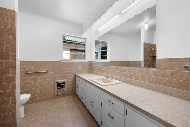 bathroom with tile patterned floors, heating unit, vanity, tile walls, and ornamental molding