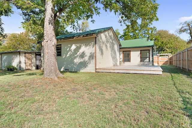 back of house featuring a lawn, a shed, and a wooden deck