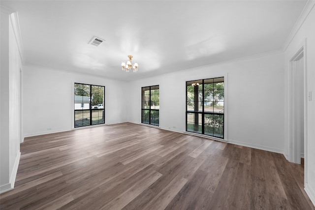 unfurnished room featuring hardwood / wood-style floors, a chandelier, and ornamental molding