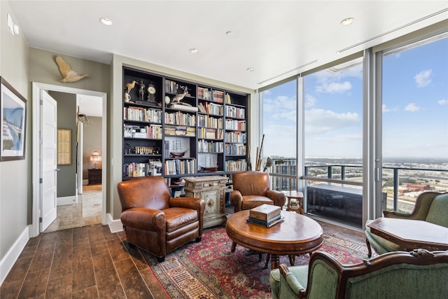 living area featuring dark hardwood / wood-style flooring and a wall of windows