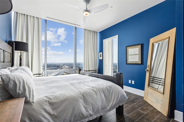 bedroom with expansive windows and ceiling fan