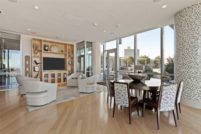 dining room with light wood-type flooring and a wall of windows