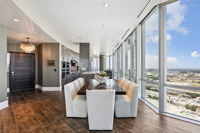 dining area featuring a notable chandelier, dark wood-type flooring, and floor to ceiling windows