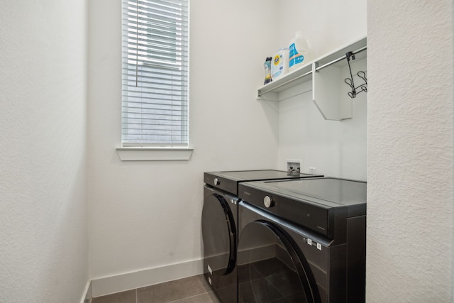 laundry room with washer and clothes dryer and dark tile patterned floors