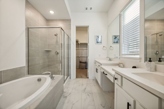 bathroom featuring vanity and independent shower and bath