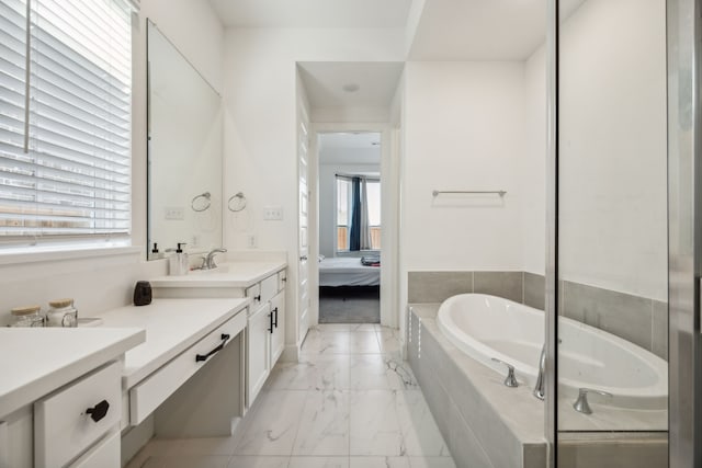 bathroom with vanity and tiled tub