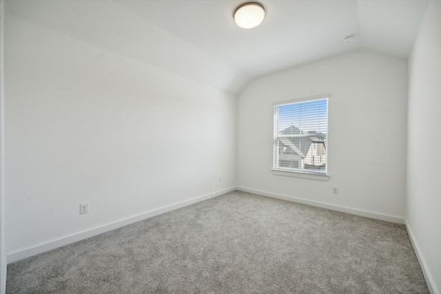 spare room featuring lofted ceiling and carpet flooring