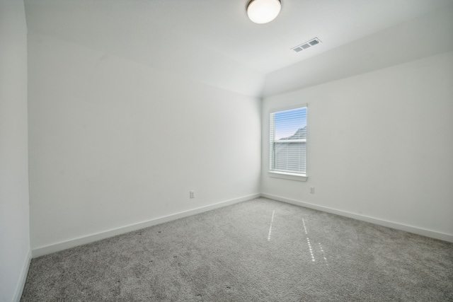 empty room featuring lofted ceiling and carpet floors