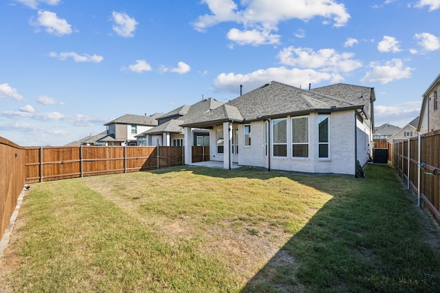 rear view of property with cooling unit and a lawn