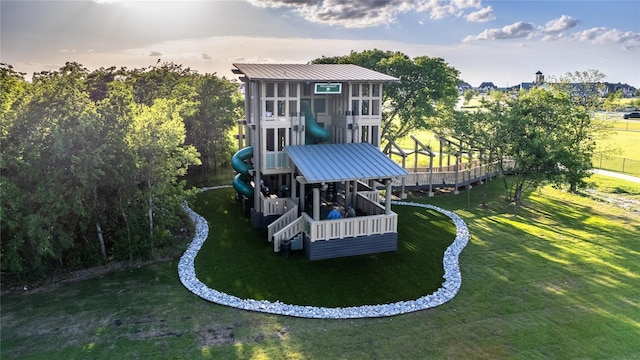 rear view of house featuring a yard and a playground