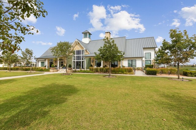 4707 Pin Oak Ct, Aubrey, TX 76227 - view of front facade featuring a standing seam roof, a chimney, metal roof, and a front lawn