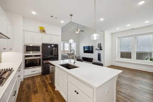 kitchen featuring white cabinets, a center island with sink, dark hardwood / wood-style flooring, sink, and stainless steel appliances