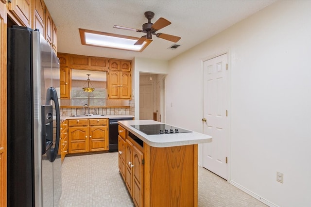 kitchen with black appliances, sink, backsplash, a center island, and ceiling fan