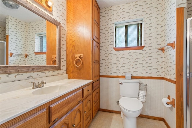 bathroom with vanity, a healthy amount of sunlight, and toilet