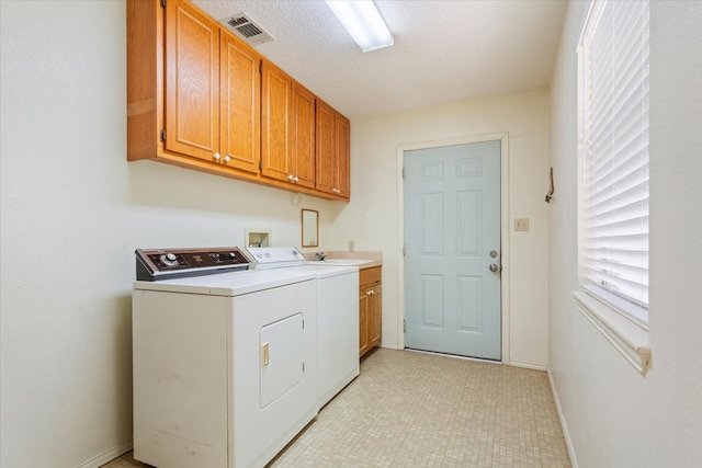 washroom featuring sink, a textured ceiling, cabinets, and separate washer and dryer