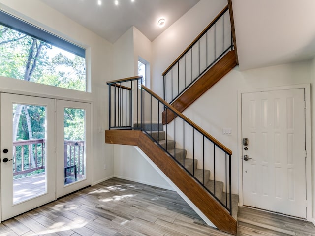 entryway with french doors, a healthy amount of sunlight, and light wood-type flooring