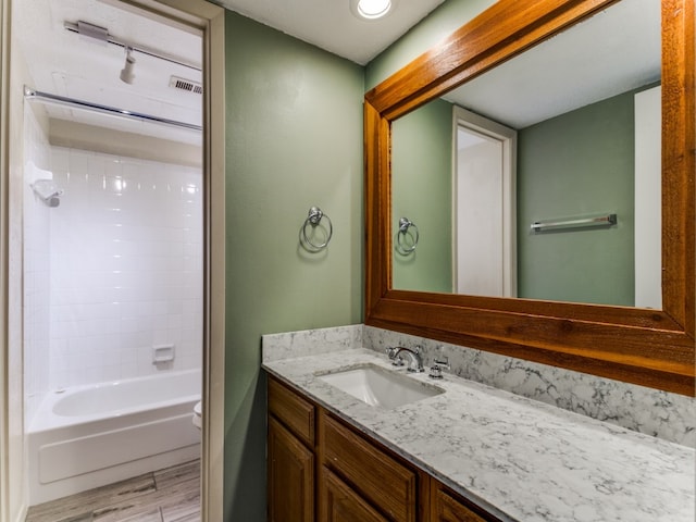 bathroom with hardwood / wood-style floors, vanity, and tub / shower combination