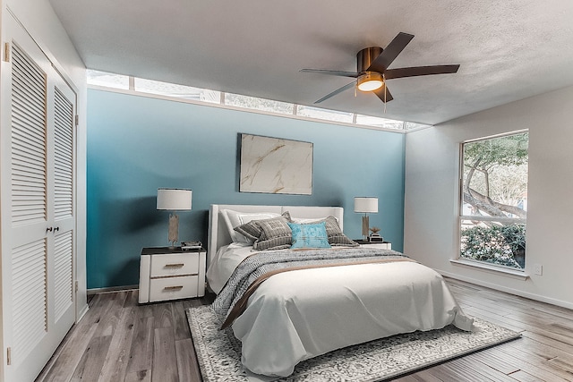 bedroom with ceiling fan, wood-type flooring, and a closet