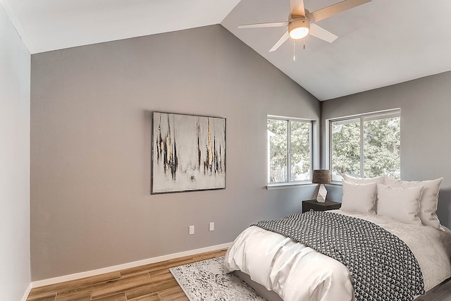 bedroom with ceiling fan, lofted ceiling, and hardwood / wood-style flooring